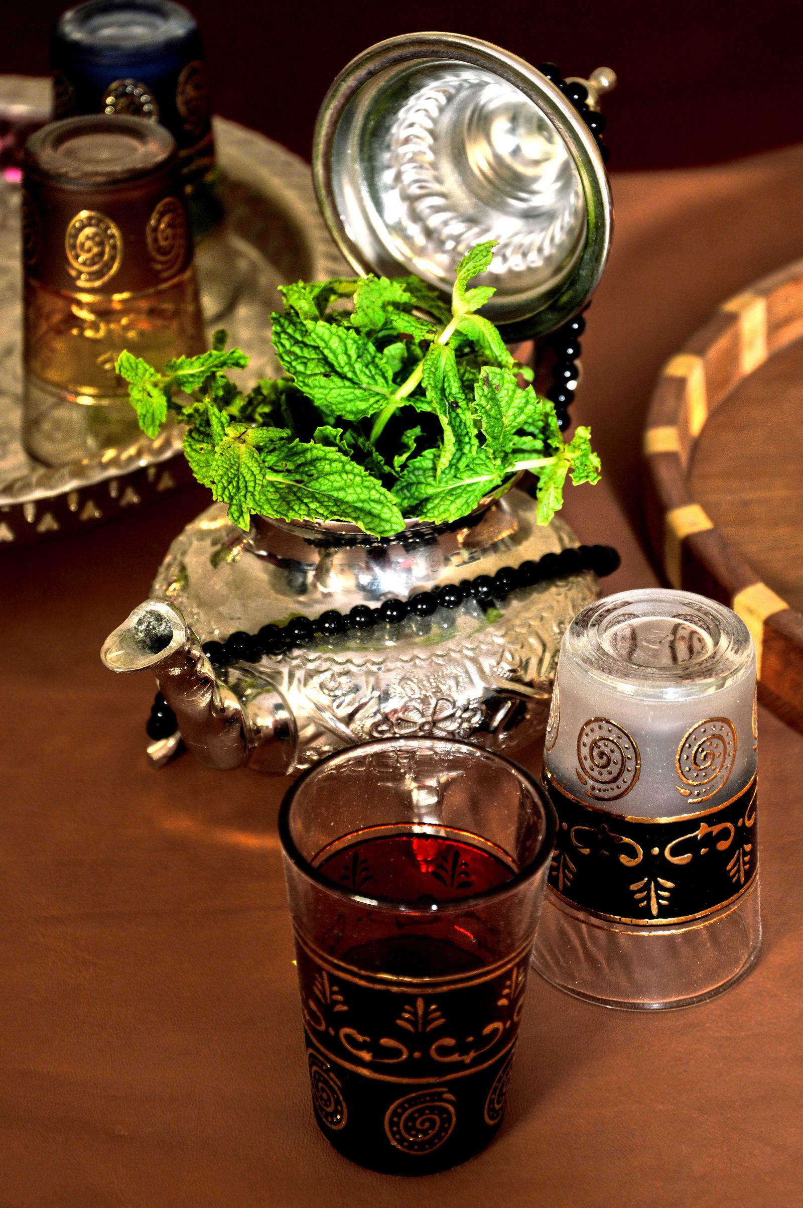 Traditional Moroccan mint tea arranged with an ornate teapot and glasses.